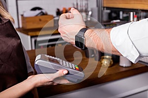 Person scanning smartwatch for payment