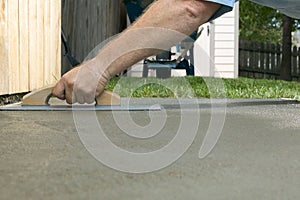 Person screeding wet cement in a backyard project