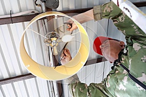 Person screws chandelier to ceiling of garage