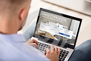 Person Searching Hotels On Laptop