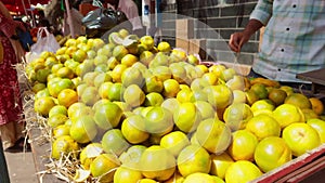 Person selling fresh oranges at a local market stall with a focus on the vibrant yellow citrus fruits