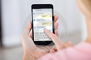 Person Sending Text Message Using Mobile Phone