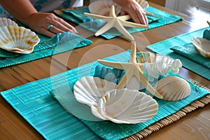 person setting a table with turquoise placemats, white starfish decorations, and shellshaped dishes