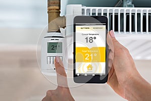 Person Setting Temperature Of Thermostat Using Mobilephone