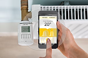 Person Setting Temperature Of Thermostat Using Mobilephone