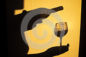 Person Shadow Holding A Wine Glass On Wall. Shadow Of man Drinking Wine