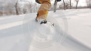 Person shooting vacation activities. Concept of extreme sport, nature, freeride. Closeup of snowboarder knee level