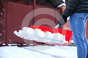 Person shoveling snow outdoors on winter day, closeup