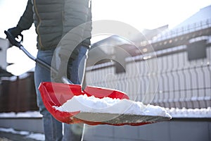 Person shoveling snow outdoors on winter day, closeup