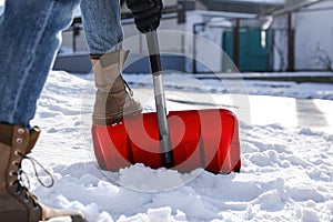 Person shoveling snow outdoors on winter day, closeup