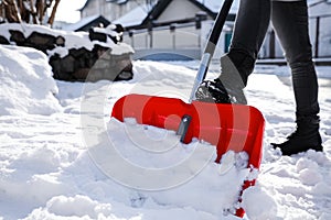 Person shoveling snow outdoors on winter day, closeup