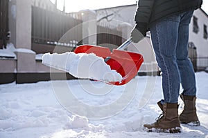 Person shoveling snow outdoors on winter day, closeup