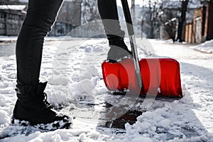 Person shoveling snow outdoors on winter day, closeup