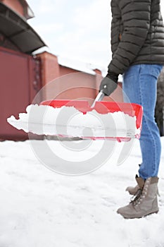 Person shoveling snow outdoors on winter day, closeup