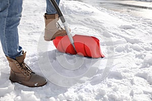 Person shoveling snow outdoors on winter day, closeup