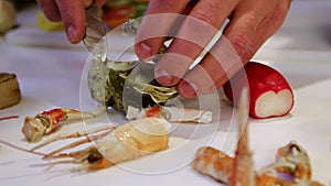 Person shucking fresh oysters with a knife, cam moves to the left, closeup