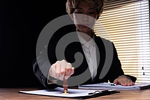 Person Signing Approval document, certificate, legal agreement in office by pen and stamp hand. Authority apply law to do contract