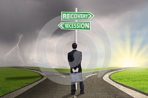 Person with signpost of recession and recovery finance photo