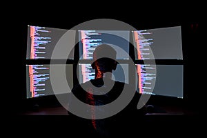 Programmer Working Late on Multiple Monitors with Code