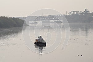 A person sitting on the boat in Yamuna Ghat at Delhi India, Yamuna Ghat view during morning time