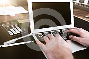 Person sitting at desk working on typing on laptop computer