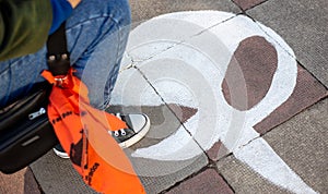 a person sitting down on the ground with an orange umbrella