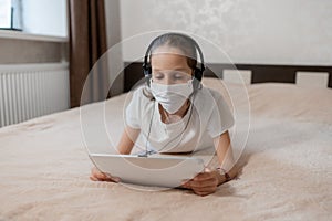 A person sitting at a table with a laptop on a bed