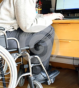Person sitting in a wheelchair at a desk with computer