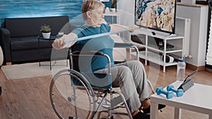 Person sitting in wheelchair and pulling resistance band to stretch