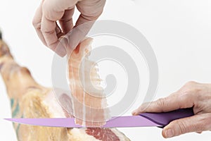 Person slicing ham slices with a knife