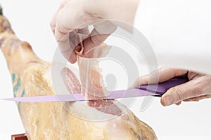 Person slicing ham slices with a knife