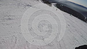 Person snowboarding from a snowy slope. Snowboarder on board rides a mountain.