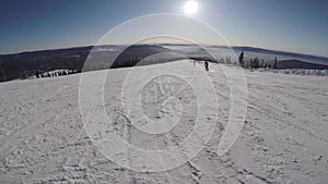 Person snowboarding from a snowy slope. Snowboarder on board rides a mountain.