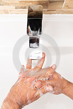 Person soaping hands under tap