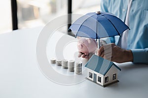 Person with stack of coins and piggy bank, saving money concept for future use.