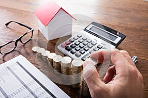 Person Stacking Coins On Wooden Desk