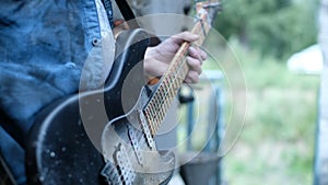 Person stand with guitar on quay ship close up hand playing cool rock music 4K.