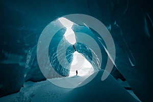 Person is standing in beautiful ice cave in VatnajÃ¶kull glacier Iceland in the winter