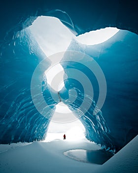 Person is standing in beautiful ice cave in VatnajÃ¶kull glacier Iceland in the winter