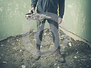 Person standing in derelict room with a dustpan