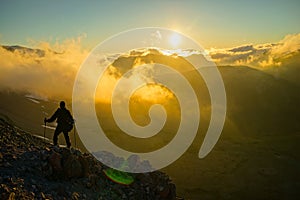 A Person Standing on the Mountain with Clouds During Sunset/Sunr