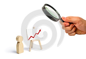 A person is standing near a chart with a red up arrow. Financial