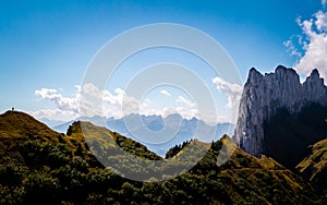 Person standing on top of a mountain summit watching on speical rock formation switzerland