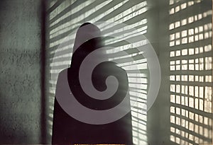 a person stands behind a slatted wall in a dark room