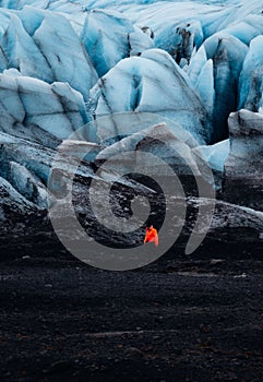 A person stands in front of an immense glacier in Reykjavik, Iceland