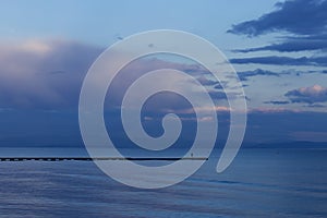 Person staying on pier during a sunset over a sea