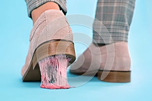 Person stepping into chewing gum on light blue background, closeup