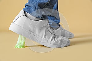 Person stepping into chewing gum on light brown background, closeup