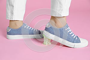 Person stepping into chewing gum on pink background, closeup