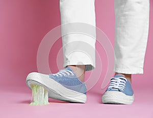 Person stepping into chewing gum on pink background, closeup. Space for text